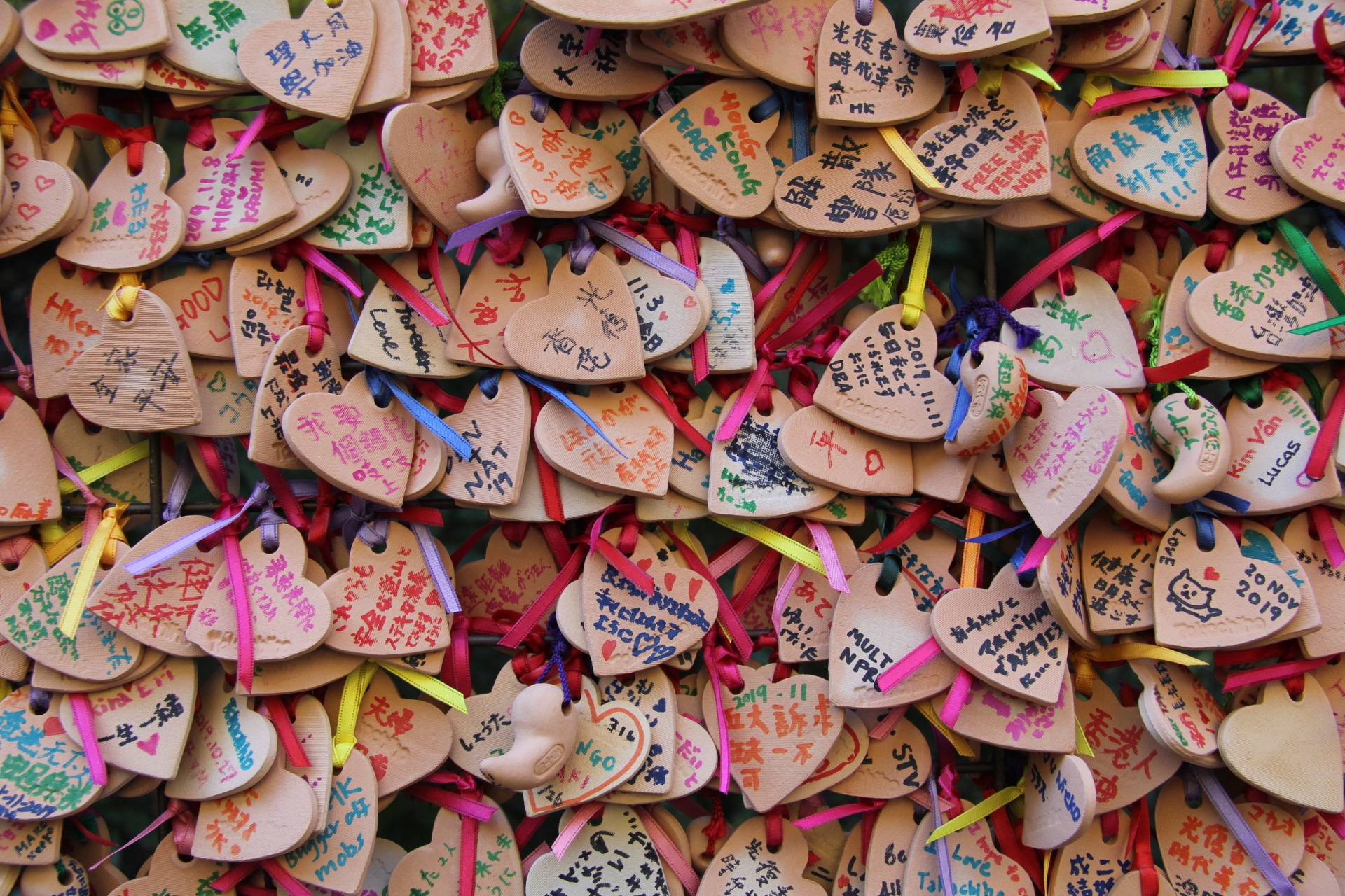 wooden heart shaped tiles with wishes written on them, a custom in japan